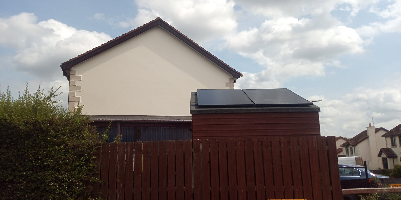 Solar panels on shed with house in background